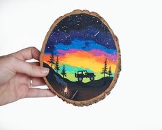 a hand holding up a piece of wood with an image of a truck on it