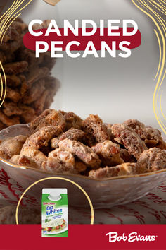 a bowl full of candied pecans sitting on top of a red and white table cloth