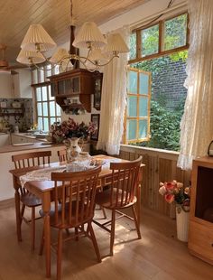 a dining room table and chairs in front of a window