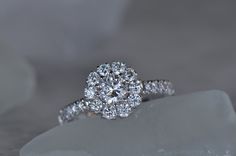 a diamond engagement ring sitting on top of a rock