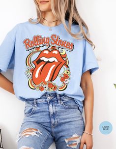 Step back in time and rock out in style with our Vintage Flower Rolling Stone Tee! 🌸🎸 This retro-inspired t-shirt features a classic Rolling Stone logo beautifully intertwined with vibrant flowers, capturing the free-spirited essence of rock 'n' roll and the timeless charm of the 70s. 🌼✨ Crafted from super-soft, high-quality fabric, this tee offers ultimate comfort and a perfect fit, making it an essential addition to your wardrobe. Whether you're heading to a concert, a festival, or just channeling your inner rock star, this tee will have you looking effortlessly cool and totally groovy. 🌟👕 Get ready to roll and bloom with style! 🌿🎶🛒 Retro Relaxed Fit T-shirt For Music Festival, Retro Graphic Print T-shirt For Spring, Crew Neck Tops For Spring Music Festival, Spring Hippie Retro Print T-shirt, Spring Crew Neck Tops For Music Festival, Spring Music Festival Crew Neck Tops, Relaxed Fit T-shirt For Spring Music Festival, Spring Music Festival Relaxed Fit T-shirt, Retro Blue Printed T-shirt