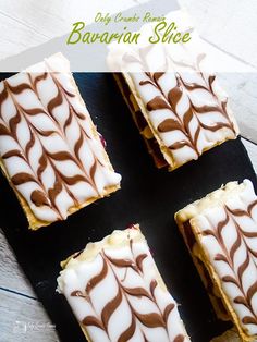 four pieces of cake sitting on top of a black plate with white and brown icing