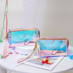 two personalized cosmetic bags sitting on top of a white table next to each other