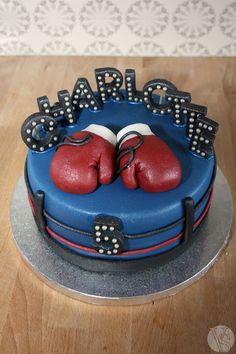 there is a cake that has two boxing gloves on top of it and the words happy birthday written in black letters