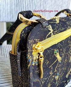 a black and gold handbag sitting on top of a white chair