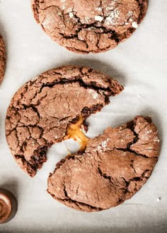 chocolate cookies with caramel drizzled on them and one half eaten cookie