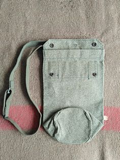 "This Unused crossbody Swiss military Gas Mask bag or shoulder messenger bag, made from salt and pepper canvas. This extremely well made bag was originally designed for Swiss Army soldiers to carry a gas mask. These days, the bag will comfortably hold an iPad mini or a kindle. It could also be perfect for carrying a water bottle and a map on a hiking trip. The shoulder strap is adjustable. The bag can either be worn over the shoulder or on a belt, as it has a loop on the back. CONDITION: perfect Military Canvas Shoulder Bag For Everyday Use, Military Style Satchel For Outdoor, Military Style Satchel Bag For Outdoor, Bicycle Panniers, Outdoor Military Satchel Bag, Military Messenger Bag, Military Bag, Medical Bag, Swiss Military