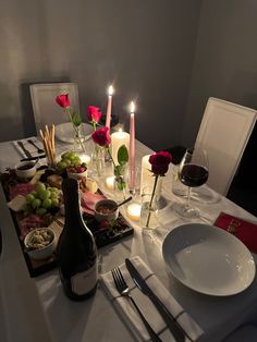 a table set with wine, food and candles