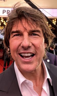 a close up of a person wearing a suit and smiling