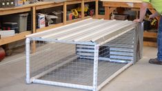 a man working on a metal cage in a shop