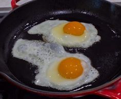 two fried eggs in a frying pan on the stove