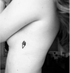 a black and white photo of a woman's arm with an ice cream cone tattoo on it