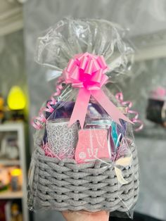 a person holding up a basket filled with items for someone to put in their house