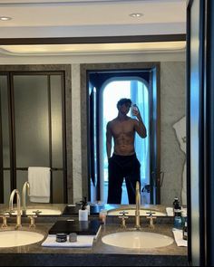 a man standing in front of a bathroom mirror taking a selfie