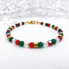 Looking for a festive Christmas beaded bracelet that will add just the right amount of sparkle to your outfit? This tasteful bracelet is the perfect choice!  The premium quality Preciosa 4mm round faceted crystal beads shimmer in shades of red, green, and clear, plus shiny gold glass beads, capturing the essence of the holiday season.  It is a perfect accessory for holiday parties, family gatherings, or as a thoughtful gift. Let this bracelet add a touch of festive magic to your ensemble! 🎄✨ Explore our collection of Christmas bracelets at https://etsy.me/48kWWWs. This bracelet is designed for style and comfort as it features a gold-plated clasp with wire guards on each end to protect the wire from wearing down over time and to prevent scratches or snags on your skin and clothing. The str Holiday Bracelets, Bracelet Elegant, Christmas Bead, Bracelet Crystal, Christmas Bracelet, Bracelet Ideas, Elegant Red, Gold Glass, Faceted Crystal