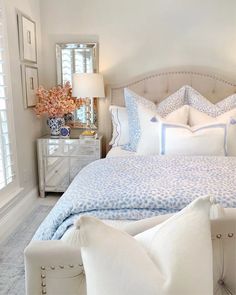 a white bed with blue and white pillows