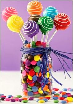 a jar filled with lots of colorful lollipops