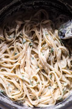 the pasta is being cooked in the crock pot with a spoon and it's ready to be eaten