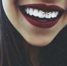 a close up of a woman's mouth with teeth and piercings on it