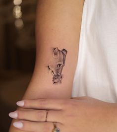 a woman's arm with a small tattoo of a cat on the left wrist