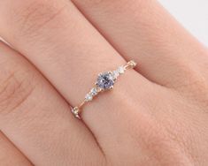 a woman's hand with a ring on it that has three stones in the middle