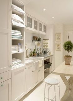 an image of a kitchen with white cabinets and counter tops, as well as pictures on the wall