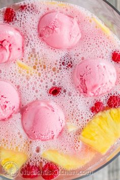 an ice cream sundae with raspberries and pineapple