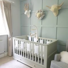 a baby crib in a room with deer heads on the wall