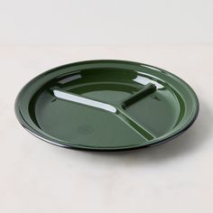 a green plate sitting on top of a white table