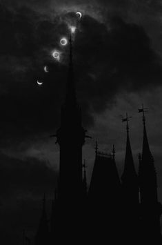 the moon is setting over an old building with steeples and spires on it