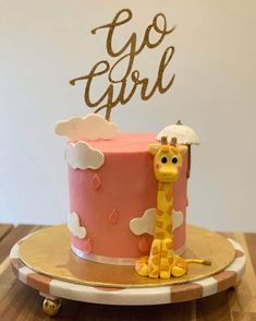 a pink and yellow cake with a giraffe on top that says go girl