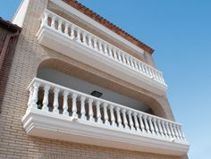 an apartment building with balcony and balconies on the second floor, against a blue sky