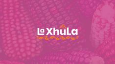 the word la xhila written in orange and pink on top of corn stalks