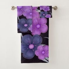 two towels hanging on a towel rack with purple flowers painted on the front and back