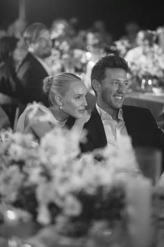 a man and woman sitting next to each other at a dinner table