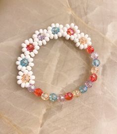 a close up of a bracelet made out of white and multicolored glass beads