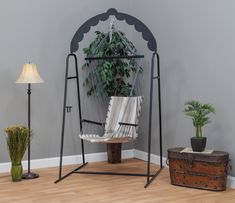 a hammock chair sitting on top of a wooden floor next to a potted plant