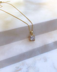 This is a classic beautiful square cz pendant framed in smaller cz's strung from a dainty 24k gold plated chain. Chain length is 16". Elegant Necklace With Square Pendant And Box Chain, Gold Diamond Necklace With Rectangular Accents, Gold Diamond Necklace With Rectangular Diamond Accents, Gold Diamond Accent Rectangular Necklace, Classic Gold Charm Necklace With Square Pendant, Gold Square Pendant Diamond Necklace With Diamond Cut, Gold Cubic Zirconia Box Chain Necklace, Classic Gold Solitaire Necklace With Square Pendant, Gold Diamond Necklace With Rectangular Pendant