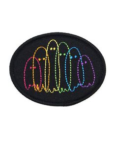 an embroidered patch with the word's logo in rainbows on black, and white background