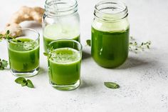 three glasses filled with green liquid next to a ginger