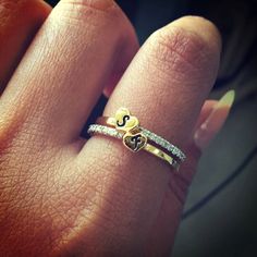 a woman's hand with a gold and white ring on top of her finger