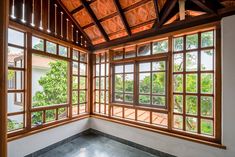 an empty room with lots of windows and wood trimmings on the ceiling is shown