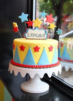 a birthday cake with stars on it sitting in front of a window