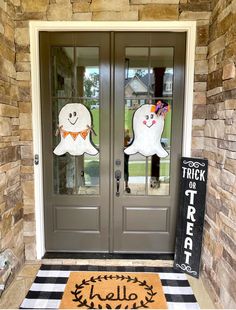 two halloween decorations on the front door of a house with black and white checkered rug