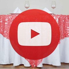 a red and white table cloth with an image of a youtube sign on it in front of two wine glasses