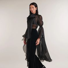 Introducing Paris, a captivating black sheer silk organza shirt exuding elegance and allure. Featuring a classic collar, covered button placket, and a removable tie for versatile styling. The gathered sleeves and cascading ruffle add drama and sophistication. Embrace the sheer beauty of Paris, a must-have for a fashion-forward wardrobe. Body: 100% Silk Please refer to care instructions on garment Elegant Silk Chiffon Party Blouse, Elegant Silk Chiffon Blouse For Party, Fitted Organza Blouse For Formal Occasions, Elegant Sheer Blouse For Evening, Chic Silk Chiffon Blouse For Parties, Fitted Silk Chiffon Blouse For Formal Occasions, Luxury Sheer Tops For Evening, Luxury Evening Tops With Sheer Sleeves, Luxury Evening Top With Sheer Sleeves