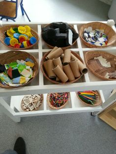 several baskets filled with different types of crafting materials on top of a white table