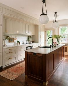 an image of a kitchen setting with white cabinets and wood floors in the center island