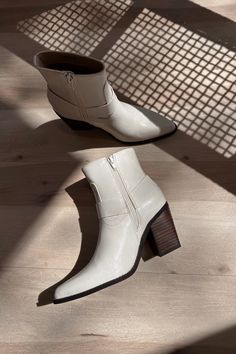 Elevate your footwear collection with the Jackson White Ankle Boots. Featuring pristine white uppers, these boots exude modern sophistication and versatility. The brown block heels provide a stylish contrast and ensure all-day comfort and stability. With convenient inner zippers, slipping them on and off is a breeze, while the outer strap details add a touch of edgy flair. The pointed toes enhance the sleek design, making these boots perfect for any occasion. The Jackson White Ankle Boots seamle White Mid-calf Boots With Stacked Heel For Fall, White Block Heel Boots For Fall, Trendy White Heeled Boots With Zipper Closure, White Ankle Heeled Boots With Zipper, White Mid-calf Boots With Stacked Heel And Pointed Toe, White Ankle Heeled Boots With Zipper Closure, White Zipper Closure Ankle Heeled Boots, Modern White Ankle Heeled Boots, White Leather Heeled Boots With Zipper