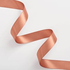 a roll of copper colored satin ribbon on a white background with room for your text